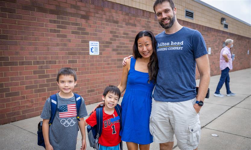 A family of four smiles on the first full day of kindergarten